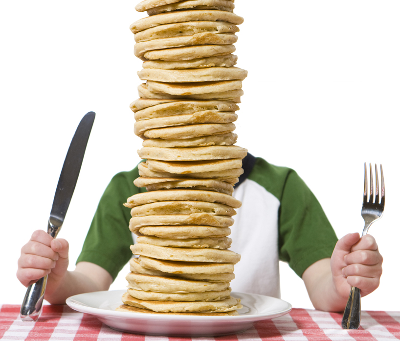 a person with too much pancake on his plate