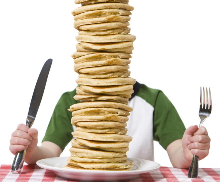 a person with too much pancake on his plate
