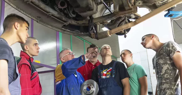 TAE40122 Certificate IV in Training and Assessment Course QLD students observing a trainer deliver hands-on automotive...